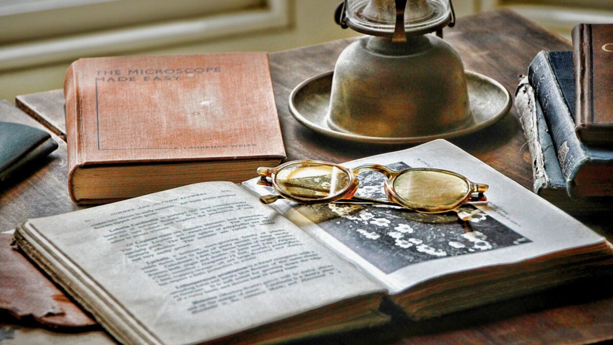 Book, old glasses and an old lantern on a table