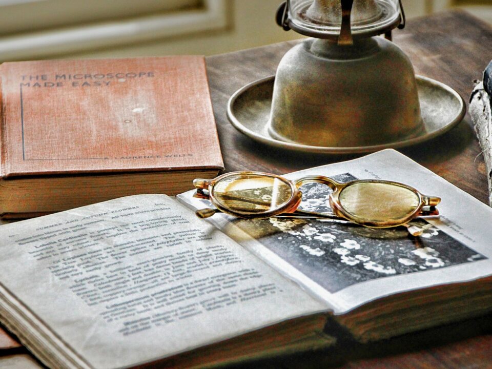 Book, old glasses and an old lantern on a table