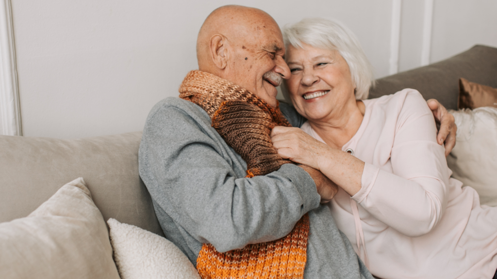 old couple on the couch cuddling and smiling - adam tobin law 